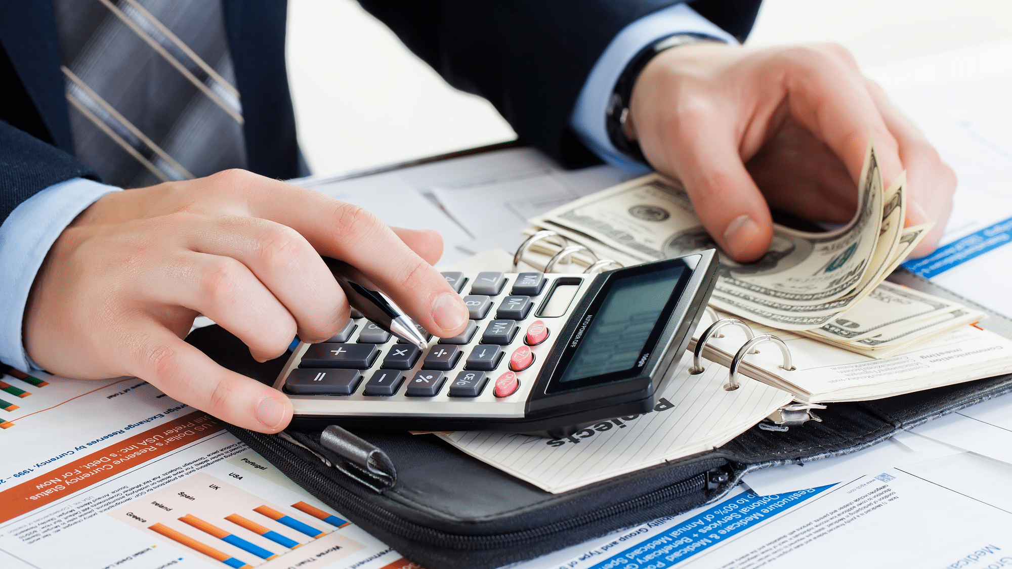 Man In Suit With Calculator & Money